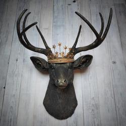 Faux taxidermy deer head wall mount painted black with gold accents. A gold Santos star crown accents the top of the deers head.