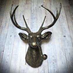 faux taxidermy deer head, painted rubbed bronze with antique gold accents. A pipe extends from the deers mouth and he has a monocle on a chain.