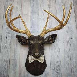 Faux taxidermy rubbed bronze deer head with gold antlers and white and gold polka dot bow tie