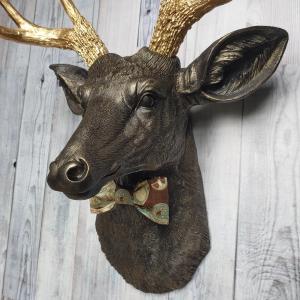 Faux taxidermy deer head painted rubbed bronze with gold antlers and a removable brown multi colored bow tie