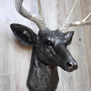 Faux taxidermy deer head, painted black with silver accenting on the deers head, the antler have been painted metallic silver.