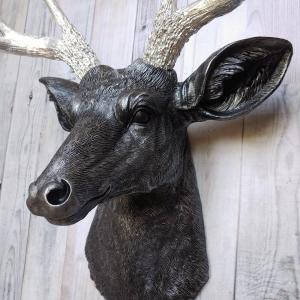 Faux taxidermy deer head, painted black with silver accenting on the deers head, the antler have been painted metallic silver.