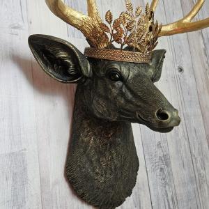 faux taxidermy deer head wall mount in black with gold accenting and gold antler. A gold metal work crown rests atop the deers head.