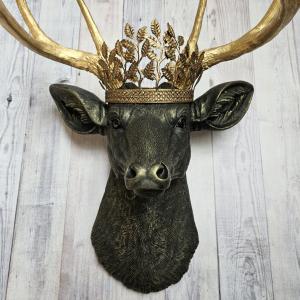 faux taxidermy deer head wall mount in black with gold accenting and gold antler. A gold metal work crown rests atop the deers head.