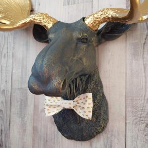 Faux taxidermy moose head painted midnight blue with metallic gold antlers. A white and gold polka dot bow tie accents the neck of the moose.