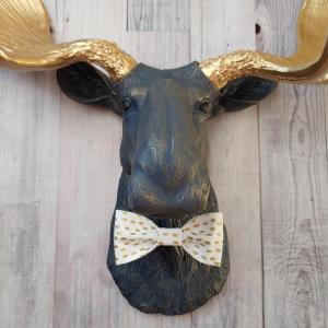 Faux taxidermy moose head painted midnight blue with metallic gold antlers. A white and gold polka dot bow tie accents the neck of the moose.