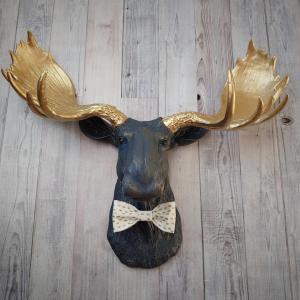 Faux taxidermy moose head painted midnight blue with metallic gold antlers. A white and gold polka dot bow tie accents the neck of the moose.