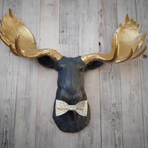 Faux taxidermy moose head painted midnight blue with metallic gold antlers. A white and gold polka dot bow tie accents the neck of the moose.