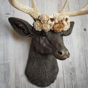 Faux taxidermy deer head, painted chestnut brown with antique white and gold accenting. Antlers are antique white with gold and chestnut brown accenting. A cream floral crown rests atop the deers head.