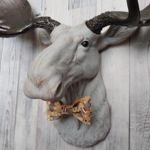Faux taxidermy  moose head, painted pale grey with bronze accenting. Antlers are painted rubbed bronze. A removable sock monkey print bow tie accents the moose's neck.