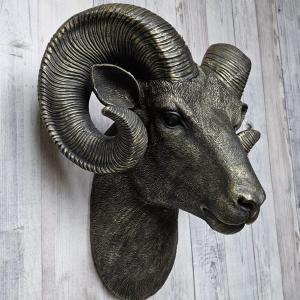 Black faux taxidermy ram head with gold accents.