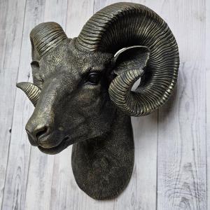Black faux taxidermy ram head with gold accents.