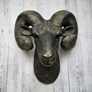 Black faux taxidermy ram head with gold accents.