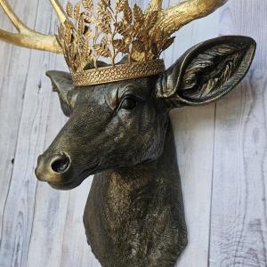 Faux taxidermy deer head wall mount, painted rubbed bronze with gold antlers and gold accents. A metal leaf work gold crown rests atop the deers head.