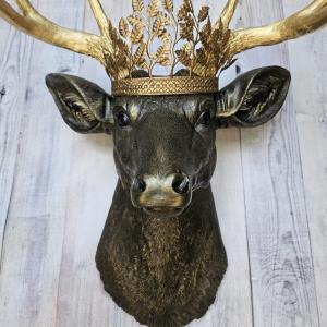Faux taxidermy deer head wall mount, painted rubbed bronze with gold antlers and gold accents. A metal leaf work gold crown rests atop the deers head.