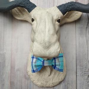Antique white moose head with slate grey antlers and a blue plaid bow tie