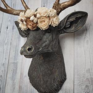 Faux taxidermy deer head, painted chestnut brown with antique white and gold accenting. The antlers are antique gold and a cream floral crown sits atop the deer head.