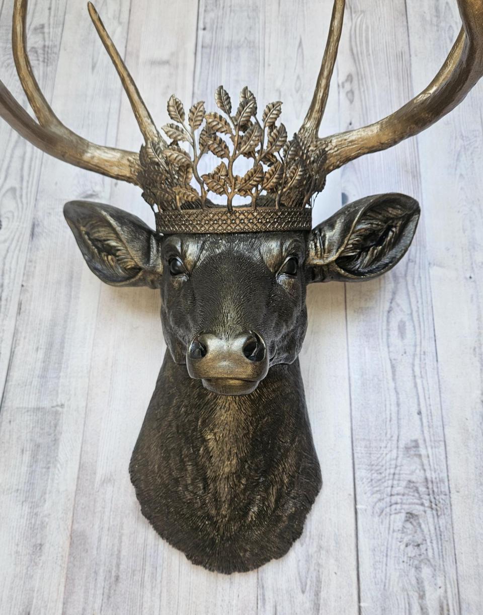 Faux taxidermy deer head wall mount. Painted rubbed bronze with antique gold accents. The antlers are antique gold and an antique gold metal leaf crown rests atop the deer head.