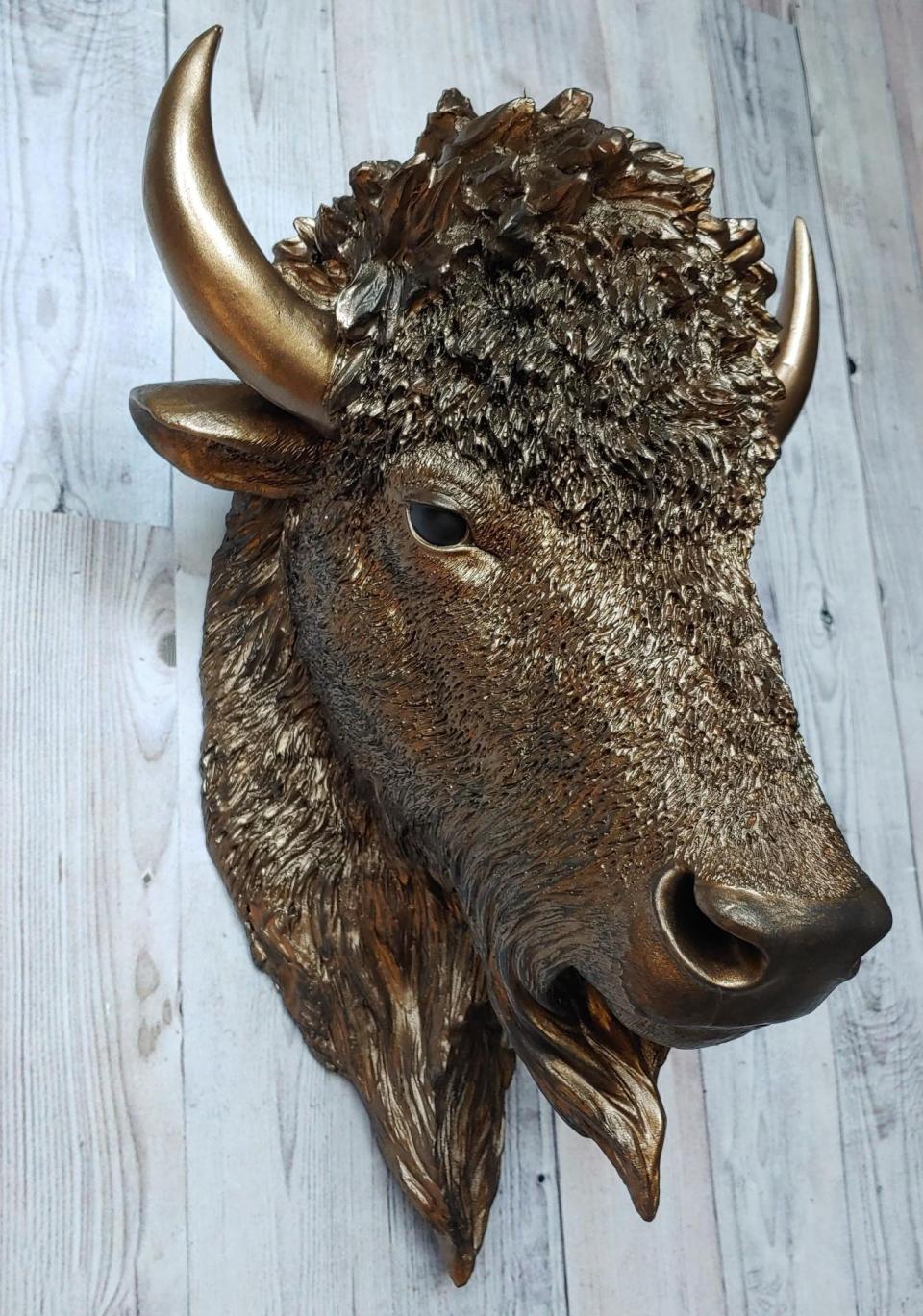 Faux taxidermy bison head, painted antique gold with black accenting.