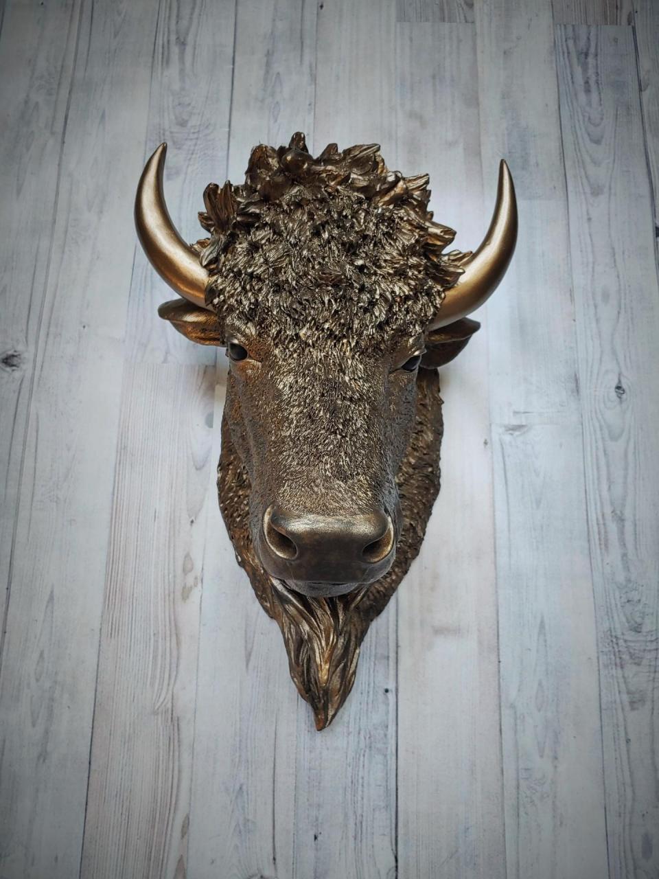 Faux taxidermy bison head, painted antique gold with black accenting.