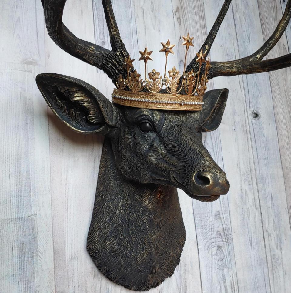 Faux taxidermy deer head wall mount painted black with gold accents. A gold Santos star crown accents the top of the deers head.