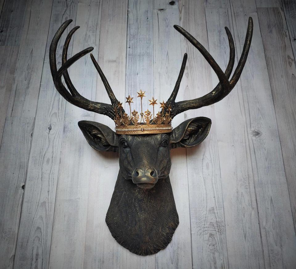 Faux taxidermy deer head wall mount painted black with gold accents. A gold Santos star crown accents the top of the deers head.