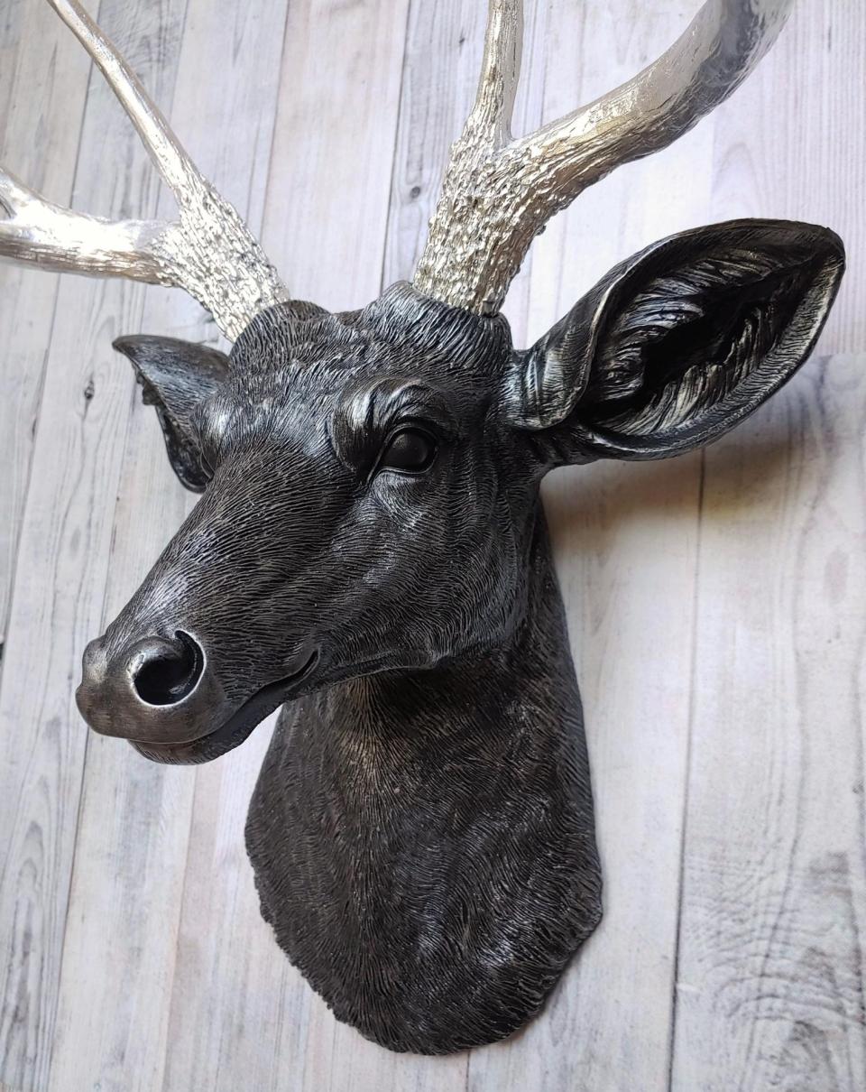 Faux taxidermy deer head, painted black with silver accenting on the deers head, the antler have been painted metallic silver.