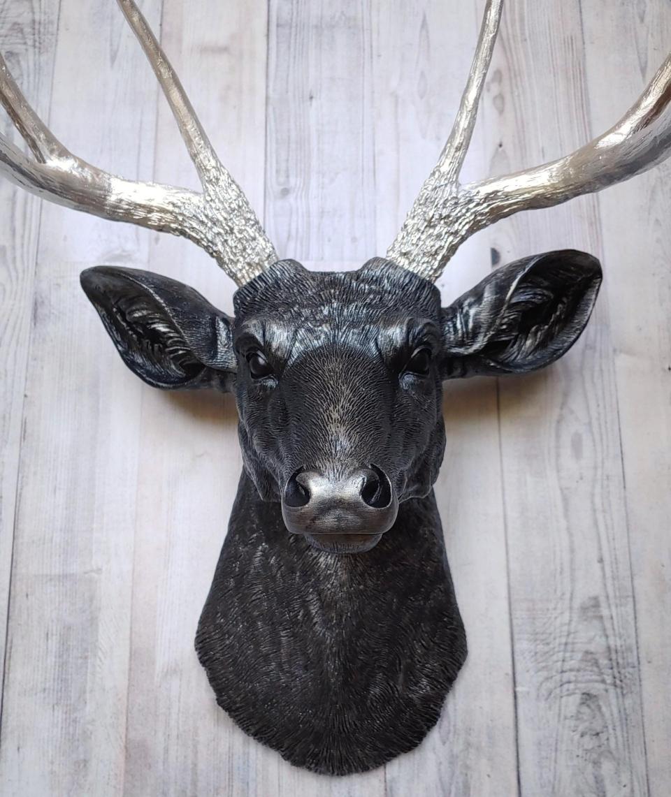 Faux taxidermy deer head, painted black with silver accenting on the deers head, the antler have been painted metallic silver.