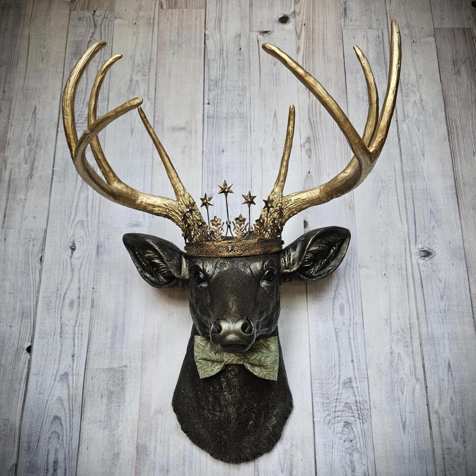 Faux taxidermy deer head wall mount with star Santos crown and a bow tie.