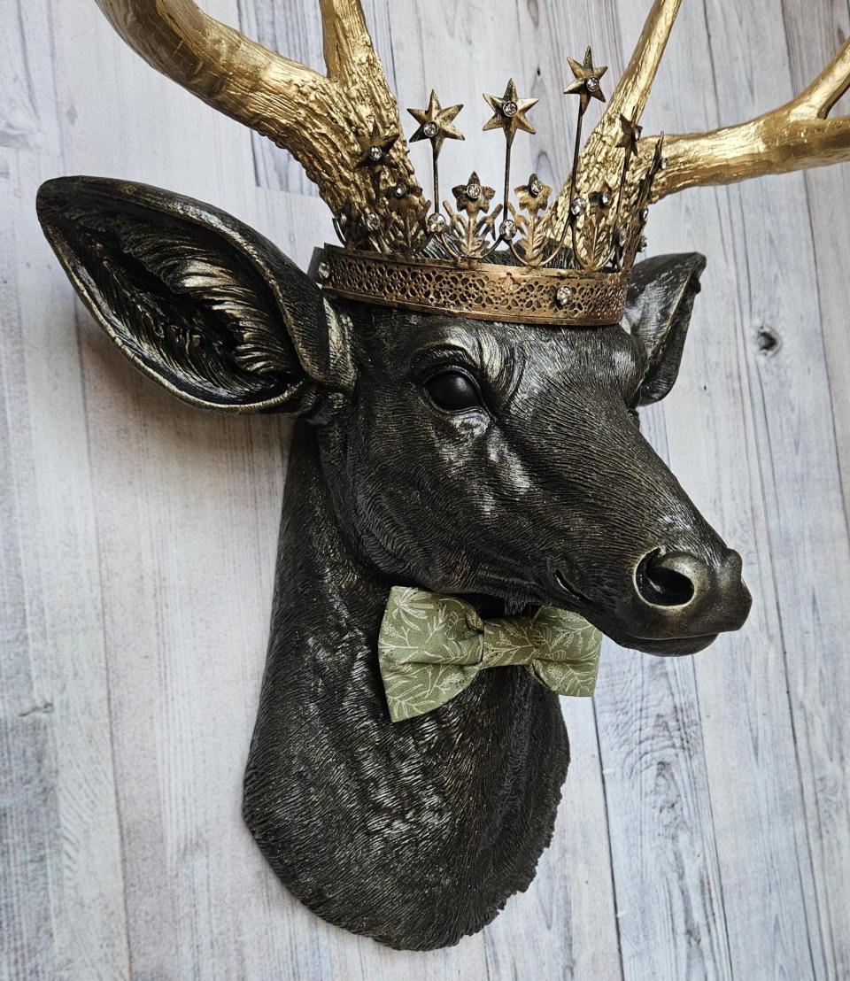 Faux taxidermy deer head wall mount with star Santos crown and a bow tie.