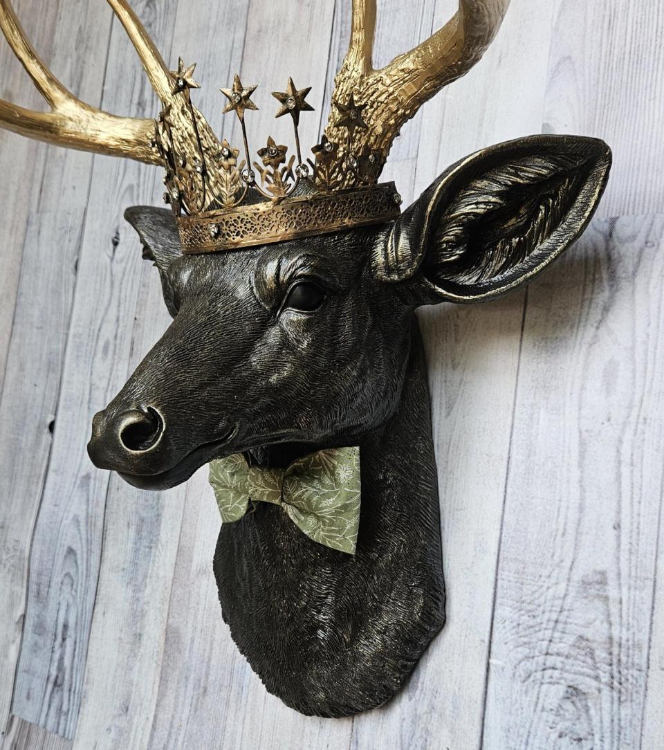 Faux taxidermy deer head wall mount with star Santos crown and a bow tie.