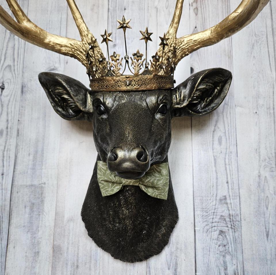 Faux taxidermy deer head wall mount with star Santos crown and a bow tie.