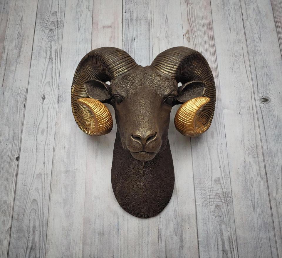 Faux taxidermy ram head, painted brown with gold tipped horns that are graduated in color.