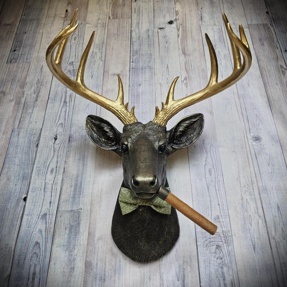 faux taxidermy deer head with cigar and bow tie.