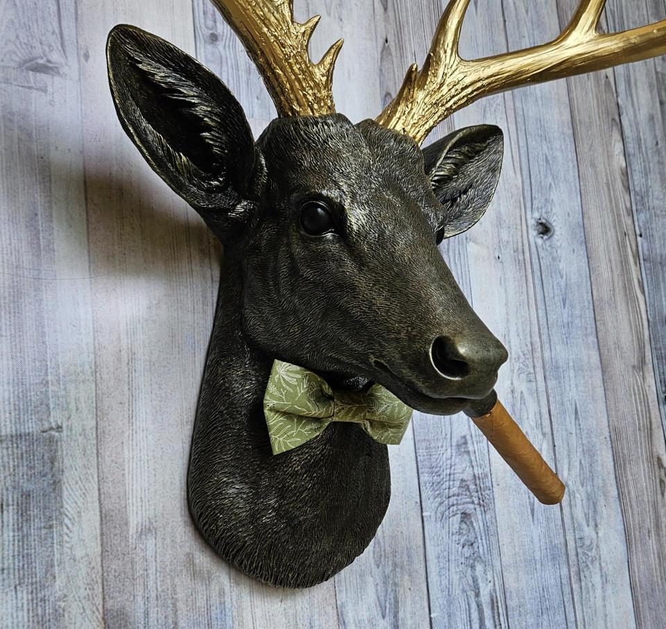 faux taxidermy deer head with cigar and bow tie.