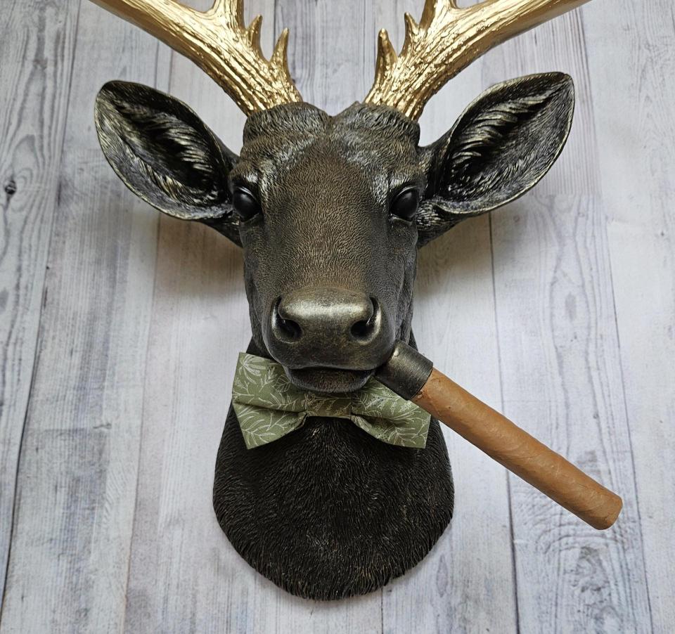 faux taxidermy deer head with cigar and bow tie.