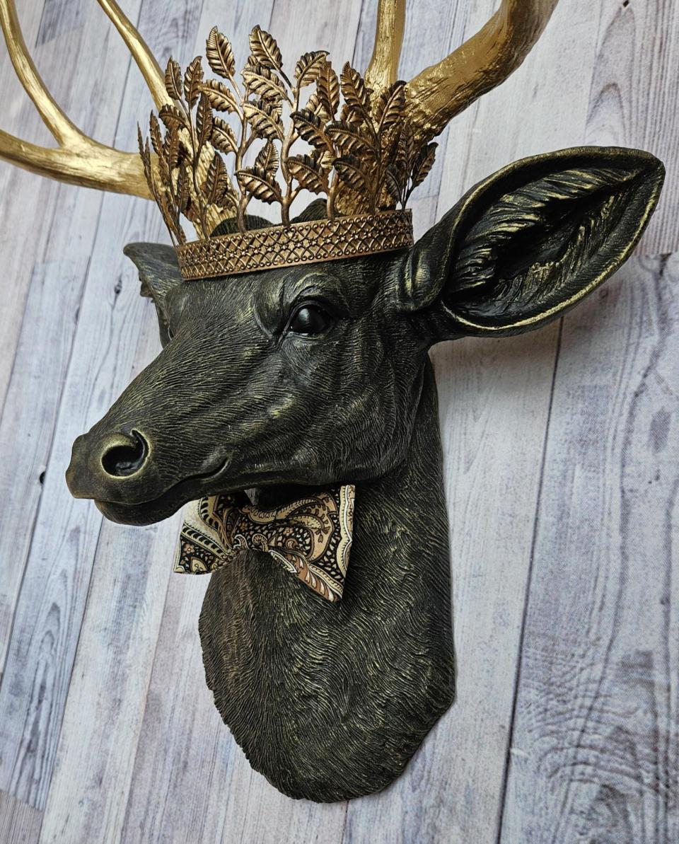 Faux taxidermy deer head with gold metal leaf crown and bow tie.
