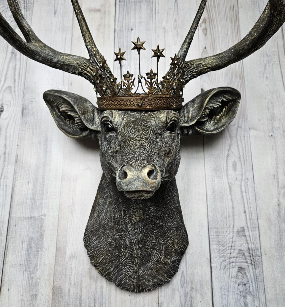 faux taxidermy deer head that's been painted chestnut brown with gold and antique white accents, the antlers are painted in the same color combination. A vintage bronze Santos metal crown with rhinestones accents the top of the deers head.
