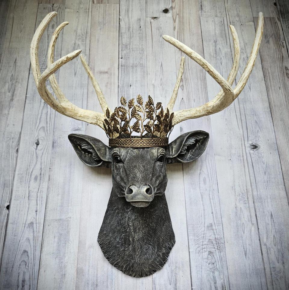 faux taxidermy deer head wall mount. Painted in a chestnut brown, antique white and gold finish with a antiqued gold metal leaf crown on the top of its head.