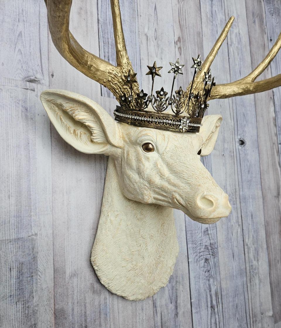 Faux taxidermy deer head wall mount, painted antique white with gold accents and gold antlers. A vintage rhinestone encrusted Santos star crown rests atop the deers head.