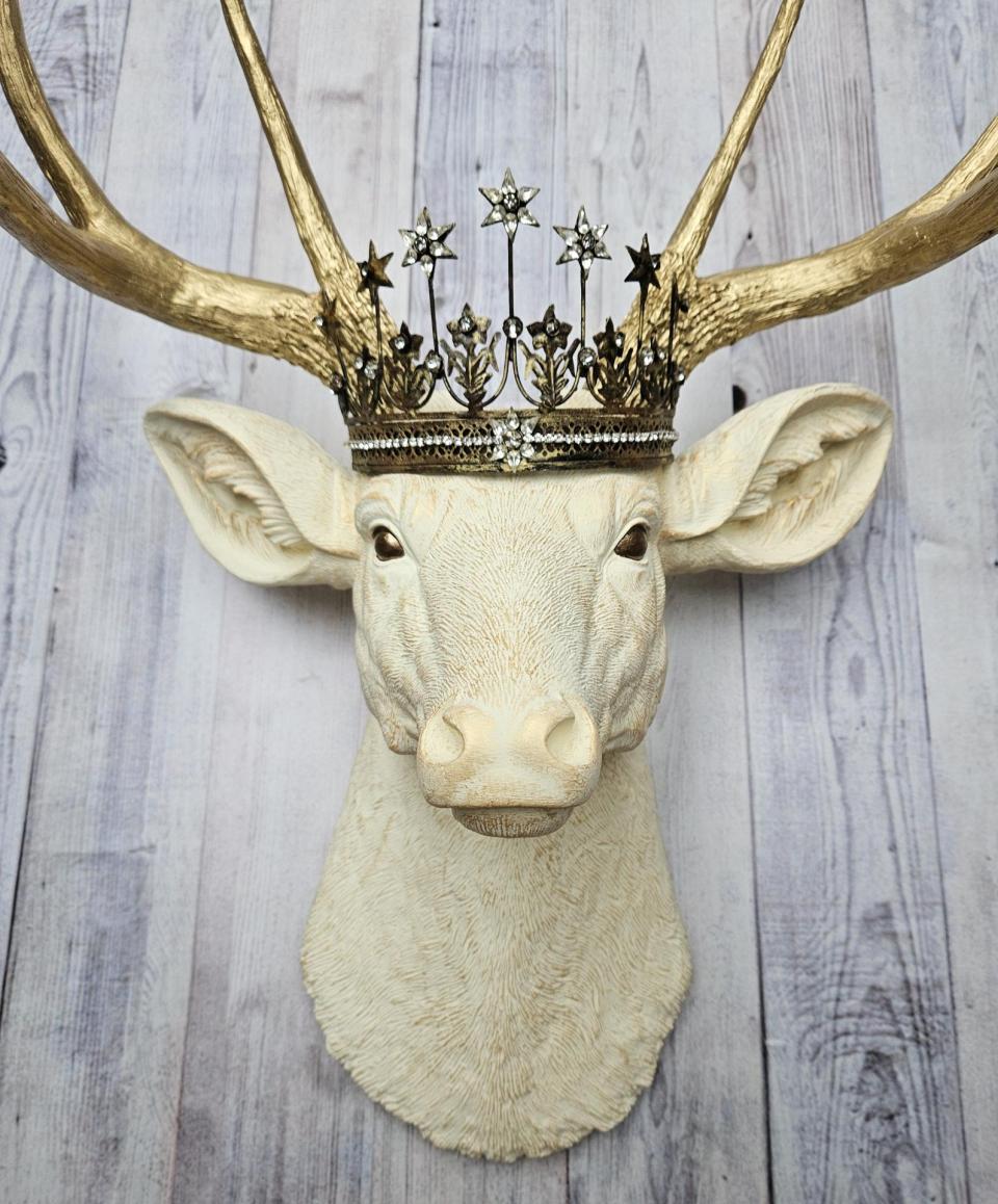 Faux taxidermy deer head wall mount, painted antique white with gold accents and gold antlers. A vintage rhinestone encrusted Santos star crown rests atop the deers head.