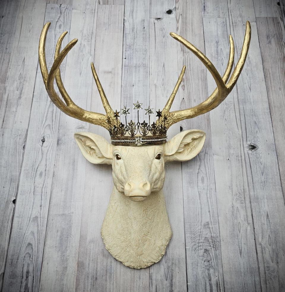 Faux taxidermy deer head wall mount, painted antique white with gold accents and gold antlers. A vintage rhinestone encrusted Santos star crown rests atop the deers head.