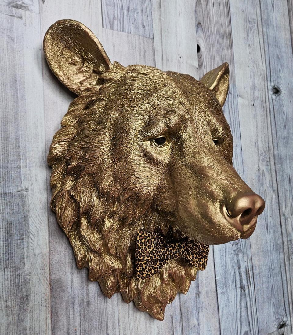 faux taxidermy bear head wall mount, painted gold with rose gold accents. a leopard bow tie accents the neck of the bear