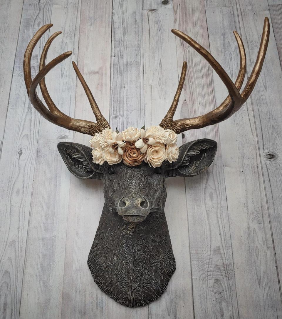 Faux taxidermy deer head, painted chestnut brown with antique white and gold accenting. The antlers are antique gold and a cream floral crown sits atop the deer head.