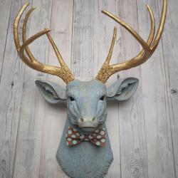 Faux taxidermy deer head painted winter blue with gold antlers and a removable brown and blue polka dot bow tie