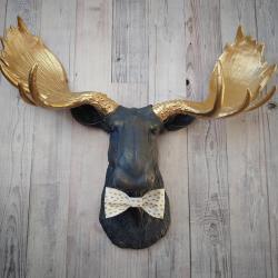 Faux taxidermy moose head painted midnight blue with metallic gold antlers. A white and gold polka dot bow tie accents the neck of the moose.