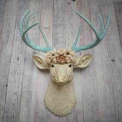 Faux taxidermy deer head, painted antique white with spa blue and gold accents. Antlers are spa blue with gold accents. A removable floral crown made out of cream sola flowers rests atop the deer head.