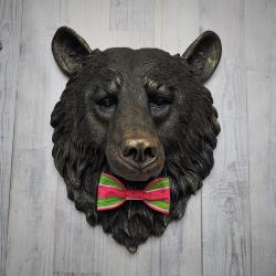 Faux taxidermy bear head wall mount, painted black with gold accenting. A watermelon print fabric bow tie accents the bears neck.