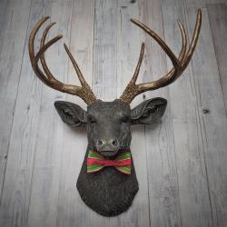 Faux taxidermy deer head painted chestnut brown and accented with antique white and antique gold. The antlers have been painted antique gold and the eyes have been painted black.Watermelon print fabric bow tie accents the deers neck.