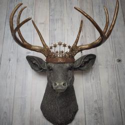 Faux taxidermy deer head, painted chestnut brown with antique white and gold accenting. The antlers are antique gold and a vintage inspired Santos crown sits stop the deers head.
